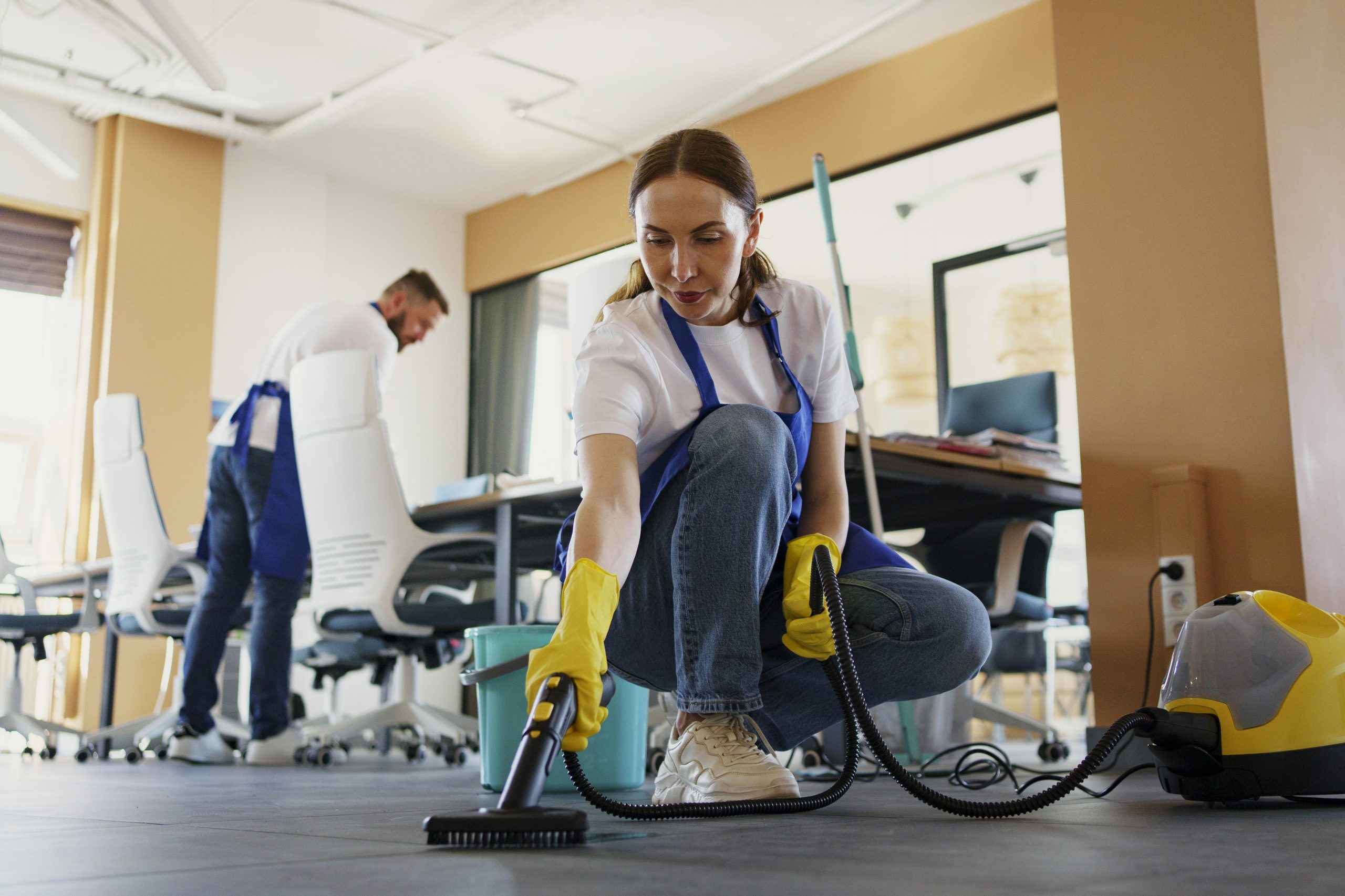 professional cleaning service expert using vacuum cleaner office